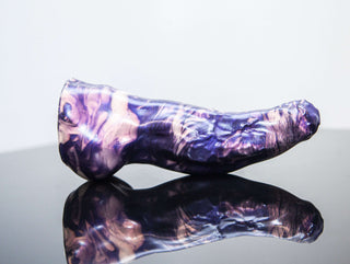 A Keith the Yeti dildo from Fantastic Kreations in purple marble with changing girth size on a black surface.