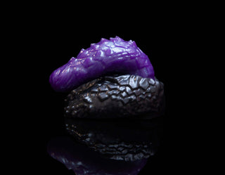 A purple and black object on a black background, featuring Drakko the Dragon packer and Fantasticocks TRANSformer packers.