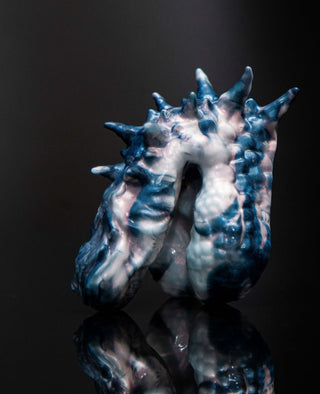 A fantasy-inspired ceramic sculpture featuring Dracul the Trans Male Packer from Fantasticocks, displayed on a black surface.